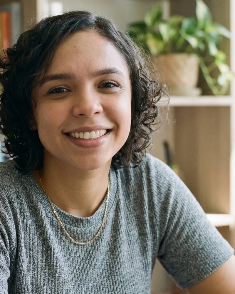Camila Duarte, psicóloga, sorrindo no consultório